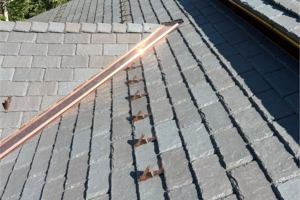 Davinci slate brownstone composite roofing material on a roof in colorado with mountains in the background