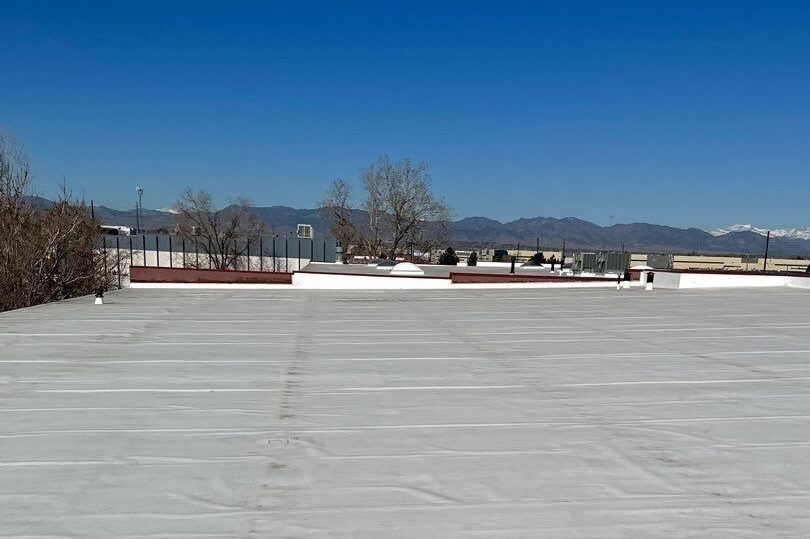 photo of commercial flat roofing material installed on a roof with a blue sky and mountains on the horizon in Golden, CO