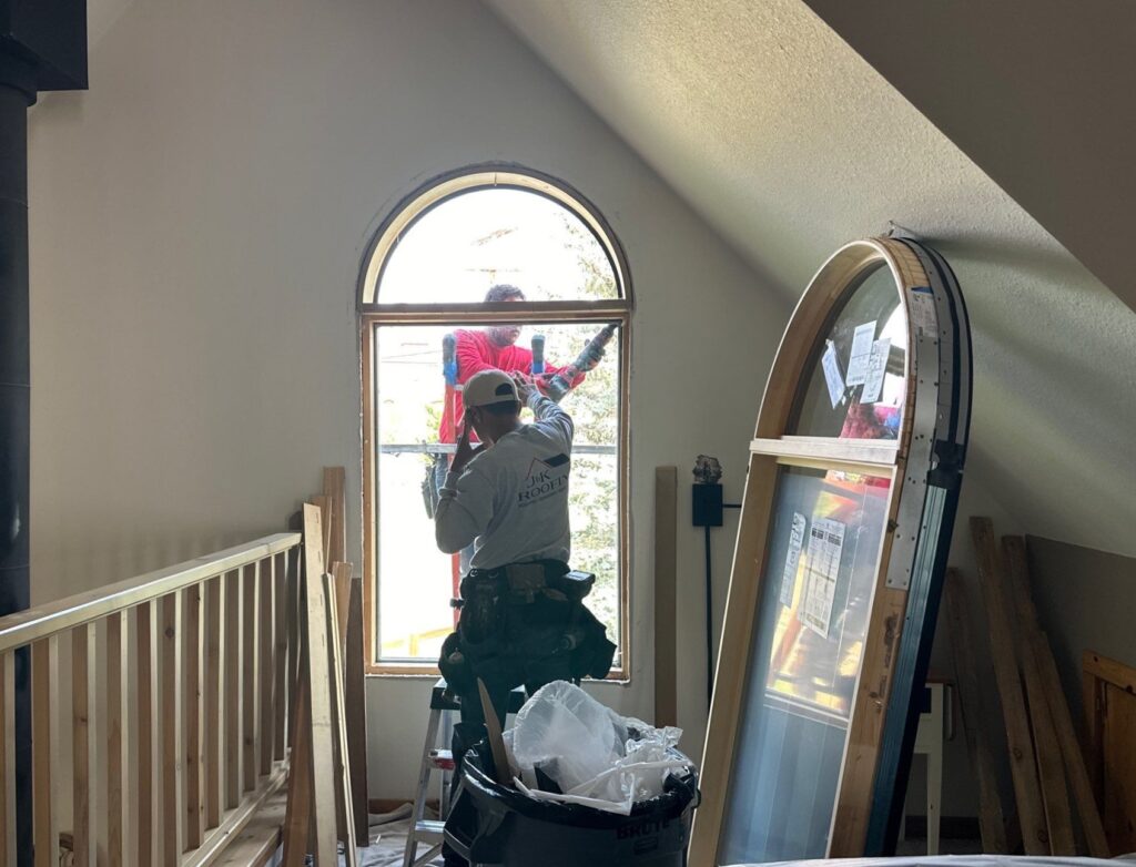 two contractors taking out an old window in a residential home to replace it with the best replacement window