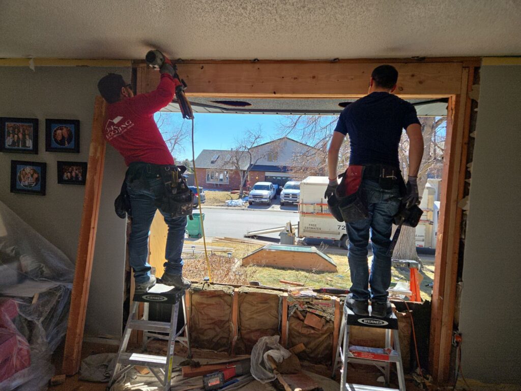 Contractors removing an old window and replacing it with a new window