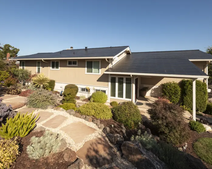 beautifully landscaped home with solar roof tiles installed 