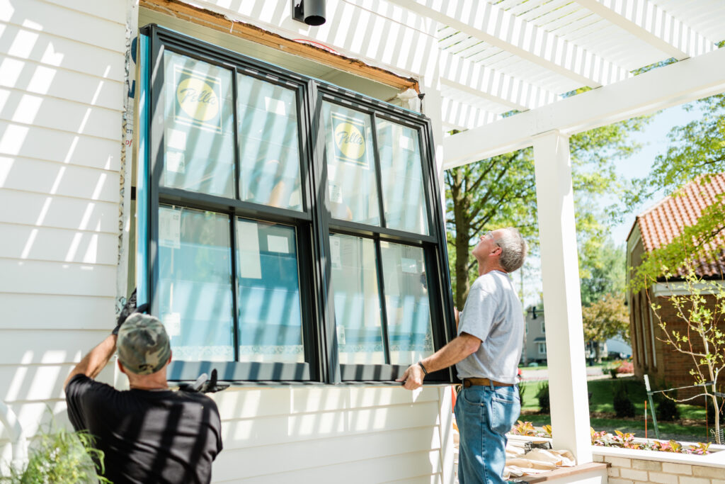 two men installing new pella brand energy efficient windows on a home in colorado