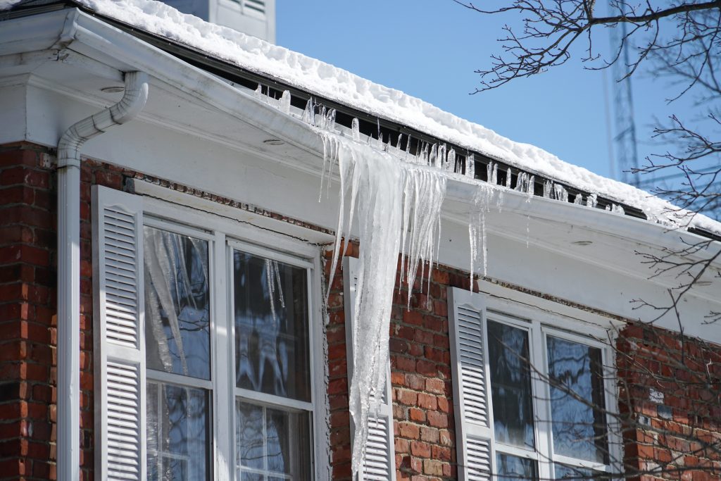 icicle on the house roof in winter season to show the importance of gutter cleaning and repair