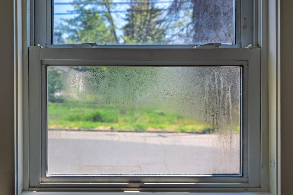 A broken thermal seal in a window, also known as a window seal failure, meaning the seal between the panes of glass has cracked, allowing air and moisture to enter.