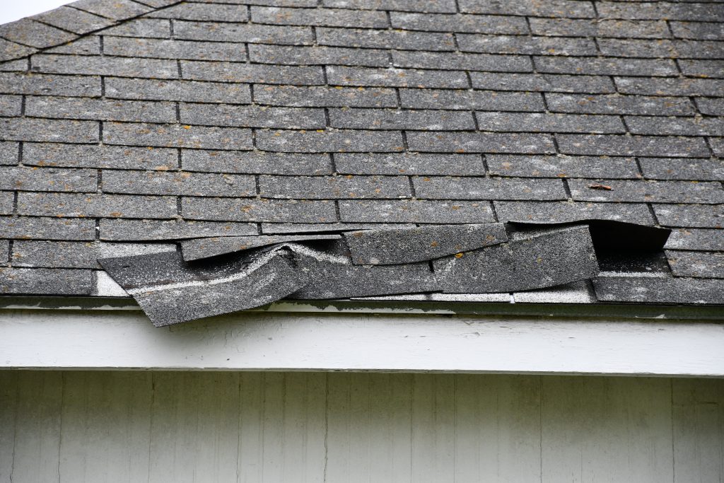 damaged asphalt shingle roof in need of roofing insurance claims